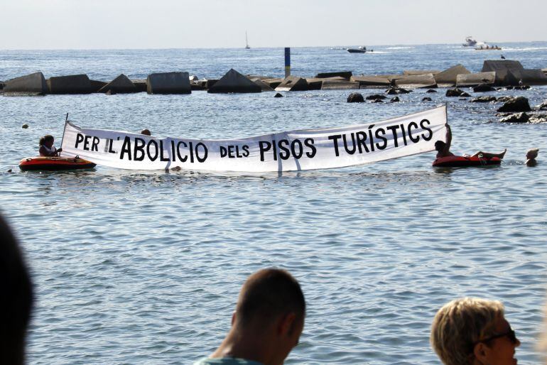 Pancarta amb el reclam &#039;Per l&#039;abolició dels pisos turístics&#039; desplegada dins l&#039;aigua en la concentració dels veïns de la Barceloneta contra els efectes de la massificació del turisme, el 12 d&#039;agost del 2017. (Horitzontal)