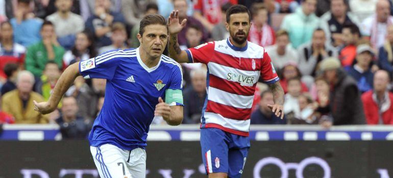 GRA317. GRANADA, 24/10/2015.- El centrocampista del Betis Joaquín Sánchez (i) pelea un balón con el centrocampista del Granada Javi Márquez durante el partido de la novena jornada de liga en Primera División que se disputa esta tarde en el estadio Nuevo l