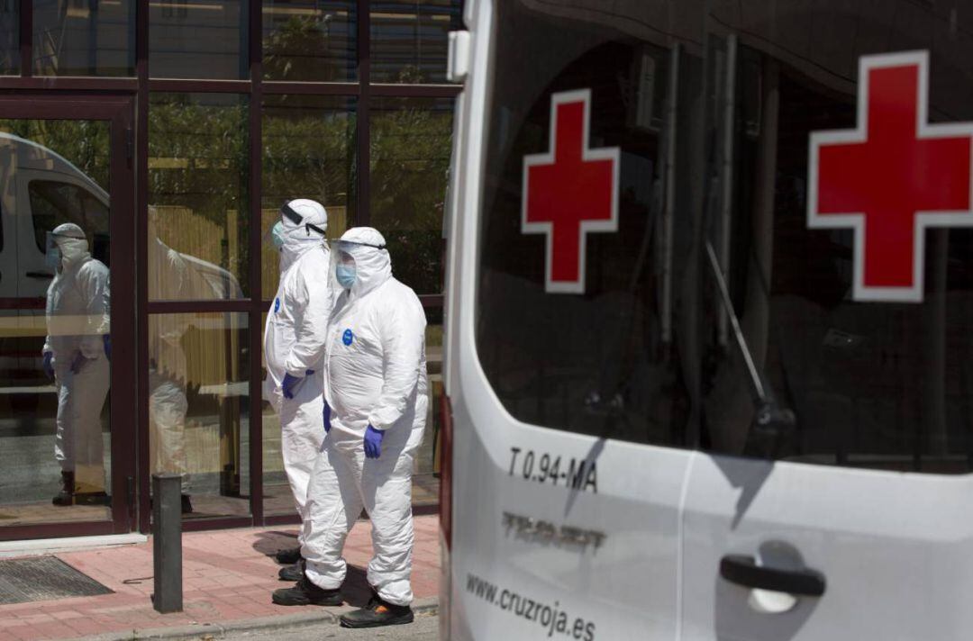 Unos sanitarios pasean en la calle protegidos por un vestuario especial