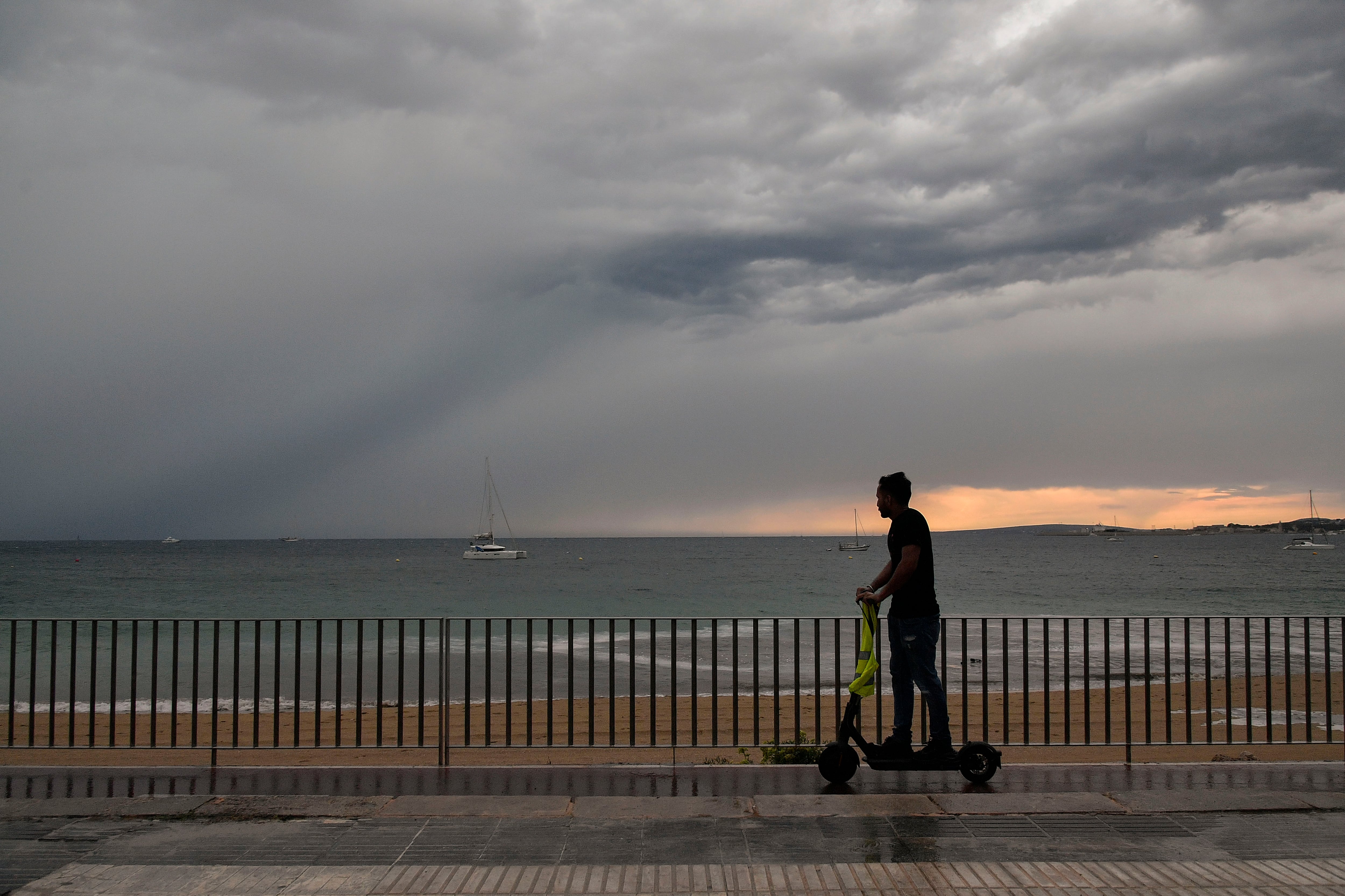 Un hombre pasea en patinete tras el paso de una Dana en Palma de Mallorca, este miércoles.