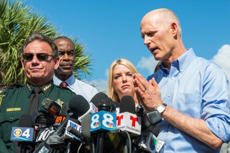  El sheriff del condado de Broward, Scott J. Israel (i), escucha el discurso del gobernador de Florida, Rick Scott (d), a las afueras de la escuela secundaria Marjory Stoneman Douglas de la ciudad de Parkland