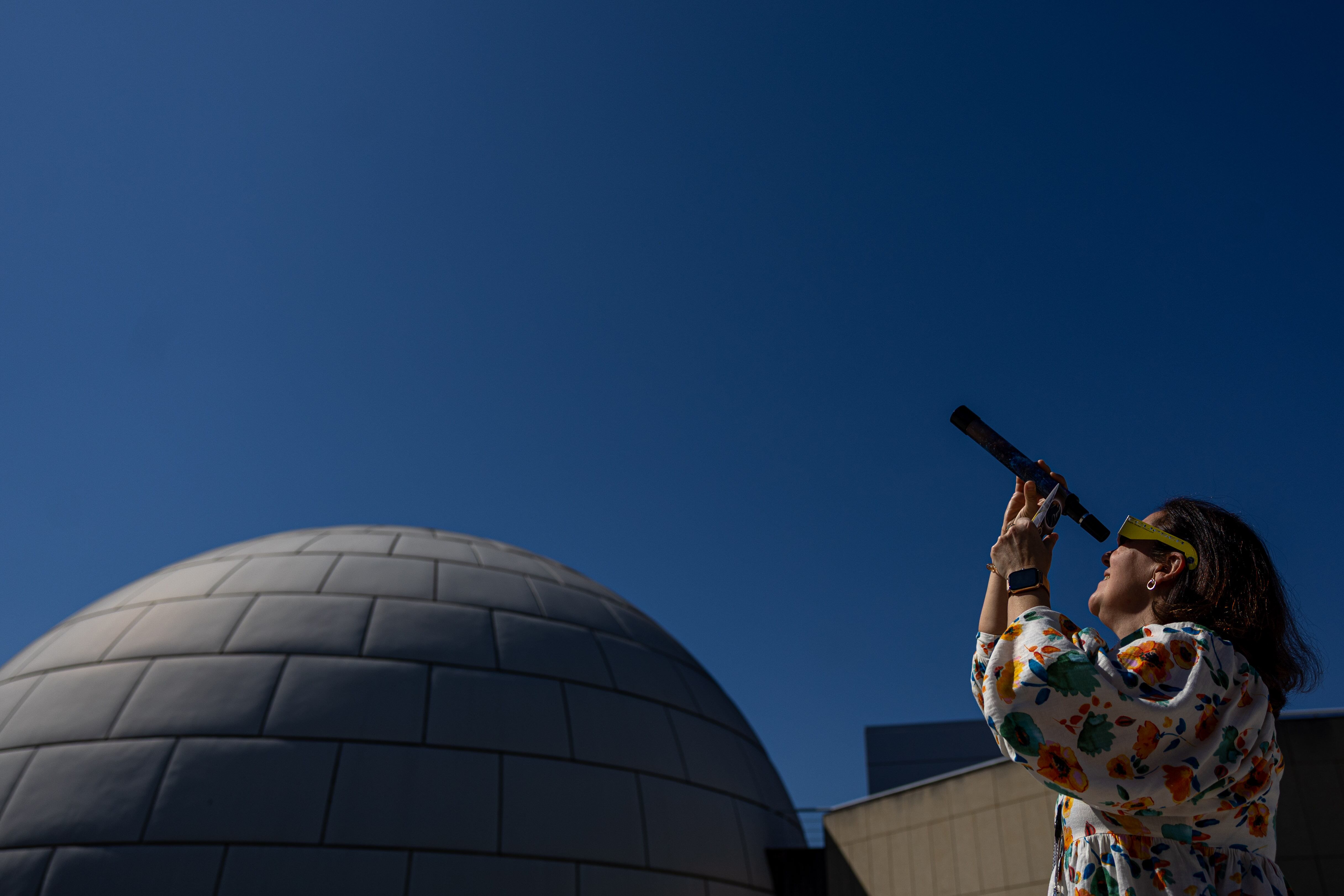 Una mujer observa el eclipse parcial de Sol, este sábado, 29 de marzo de 2025, desde el Planetario de Madrid, España. EFE/ Daniel González.