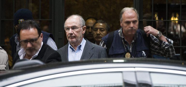 El exvicepresidente del Gobierno y expresidente de Bankia Rodrigo Rato (c) sale hoy de su domicilio de Madrid escoltado por agentes de Aduanas.