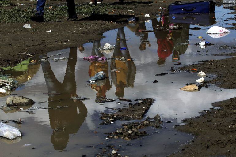 Un grupo de refugiados camina en el interior del campamento de refugiados de Idomeni, norte de Grecia, hoy 4 de marzo de 2016, donde miles de refugiados e inmigrantes esperan recibir un permiso para cruzar la frontera entre Grecia y Macedonia. La presión 