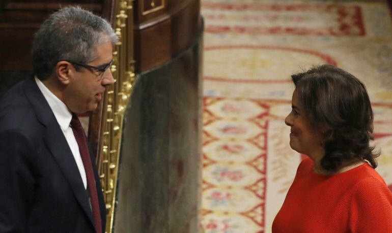 La vicepresidenta del Gobierno, Soraya Sáenz de Santamaría (d), conversa con el portavoz parlamentario de PDECat, Francesc Homs (i), durante la sesión de control al Gobierno 