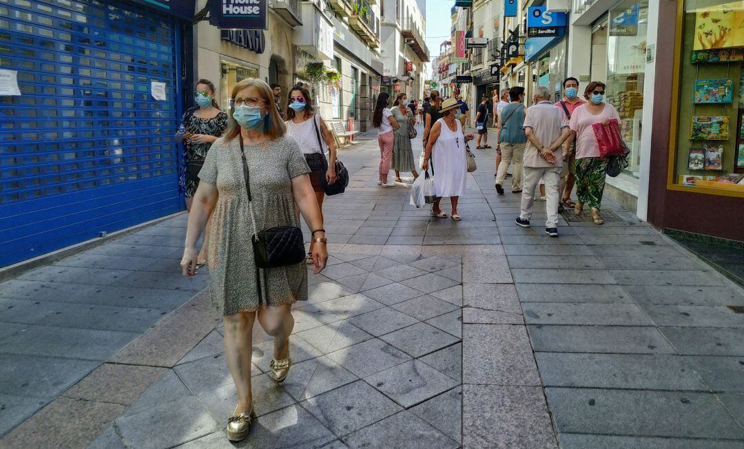 Personas con mascarilla en la calle Santa Eulalia de Mérida