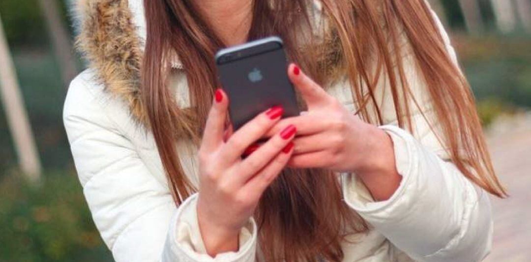 Una mujer con un teléfono en las manos.