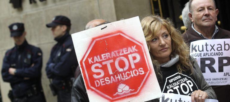 Miembros de Kaleratzeak Stop Desahucios e IRPH-STOP de Gipuzkoa participan en una concentración frente a la sede de Kutxanank en San Sebastián. EFE/Archivo