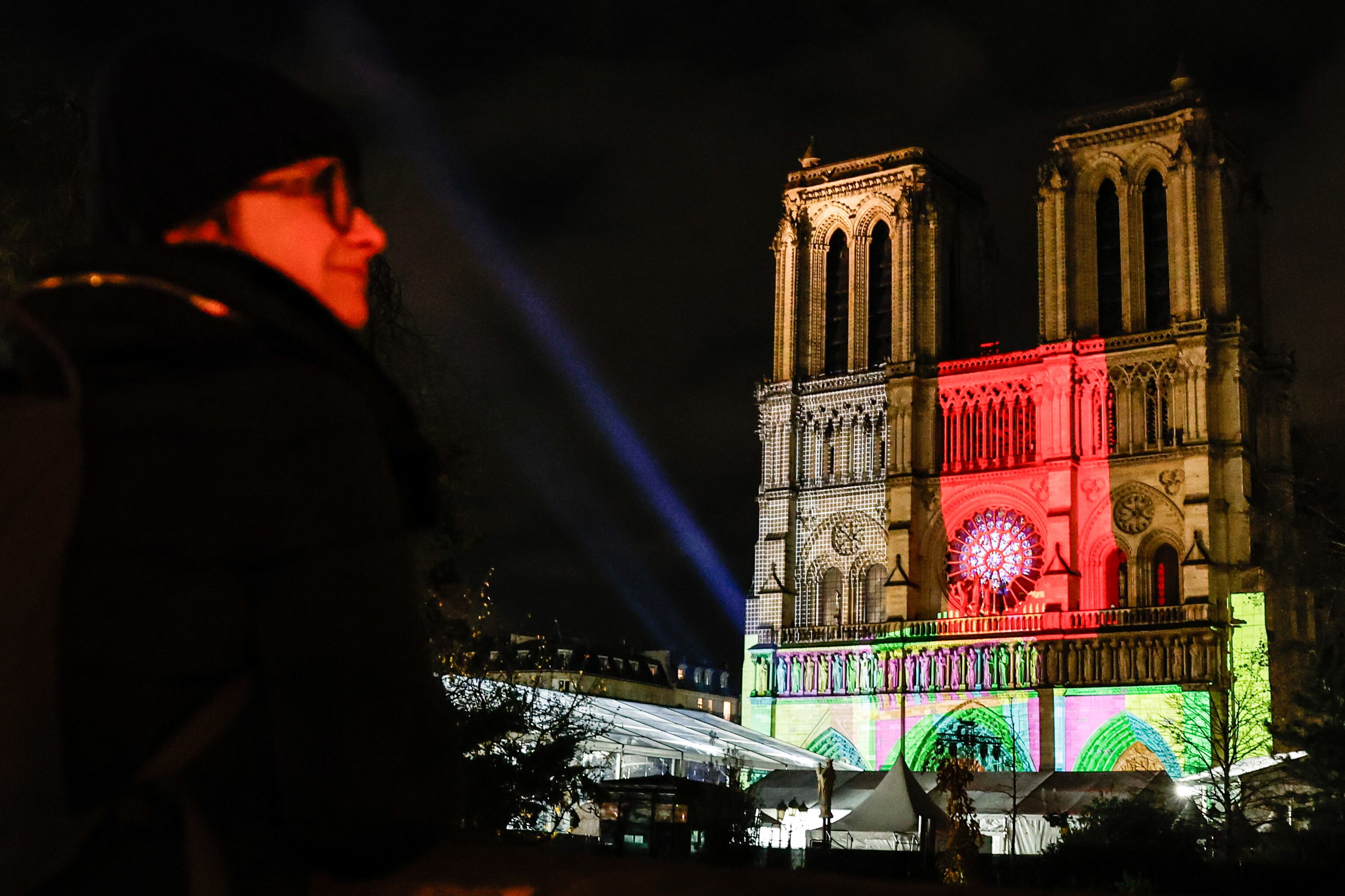 Una mujer observa este lunes la fachada de la catedral Notre-Dame de París, que se inaugurará oficialmente el 7 de diciembre