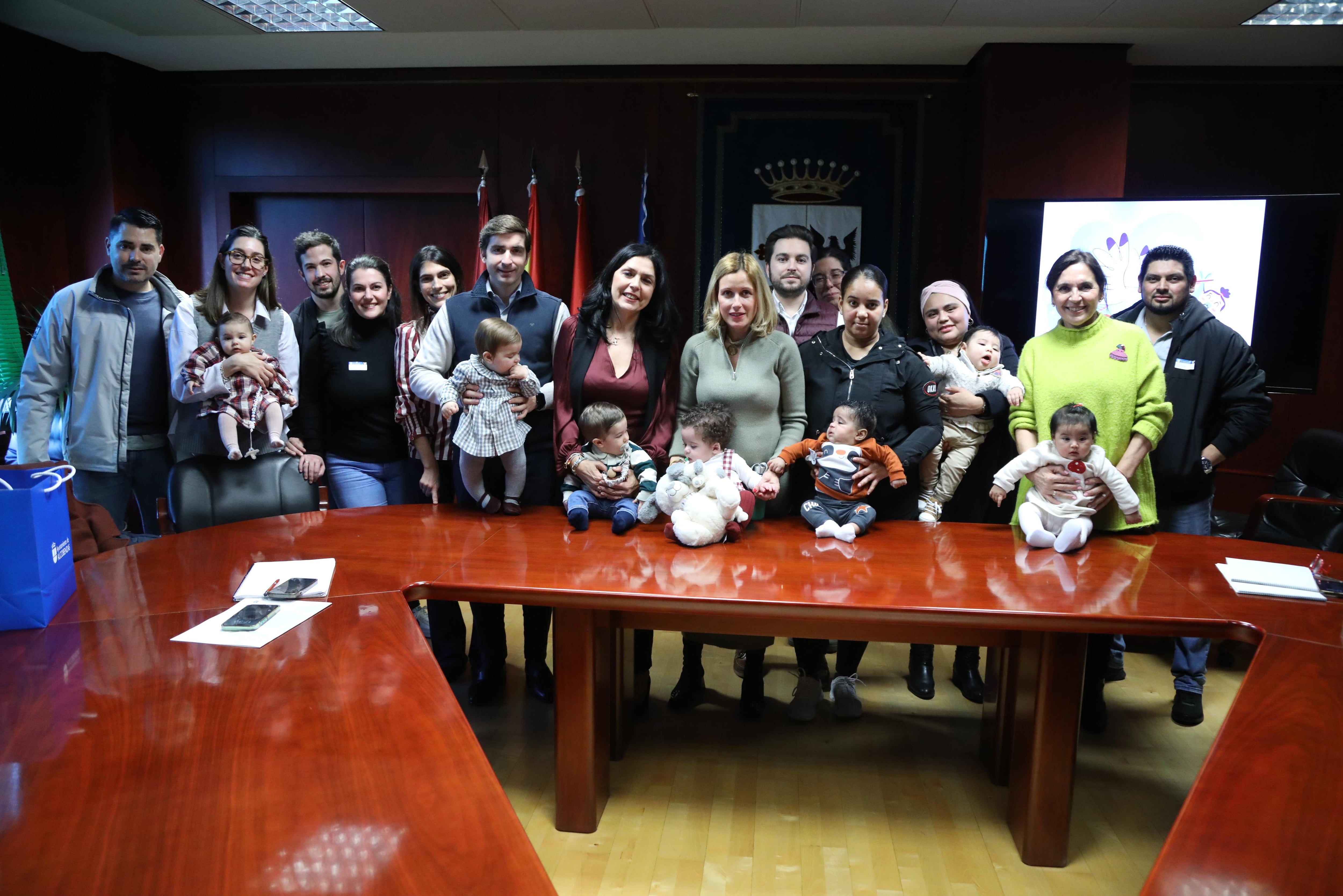 La alcaldesa de Alcobendas, Rocía García Alcántara, posando junto a algunas de las familias beneficiarias de los cheques bebé