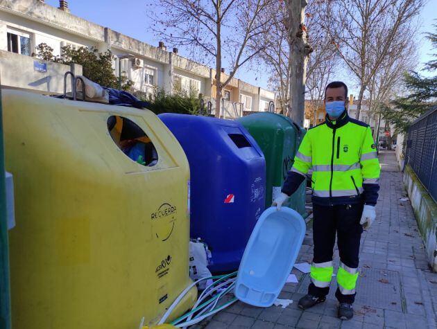 Gustavo recogiendo una bañera infantil que se encontraba tirada en el suelo junto a los contenedores de basura