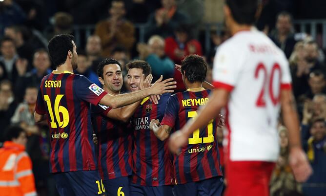 El argentino recibe la felicitación de sus compañeros tras marcar un gol de falta al Almería en el Camp Nou.