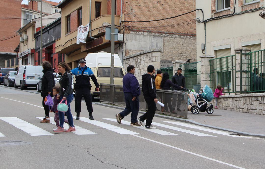 Un agente regula el tráfico a la puerta de un colegio de Cuéllar