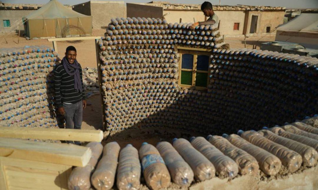 Casas con botellas de plástico en el desierto