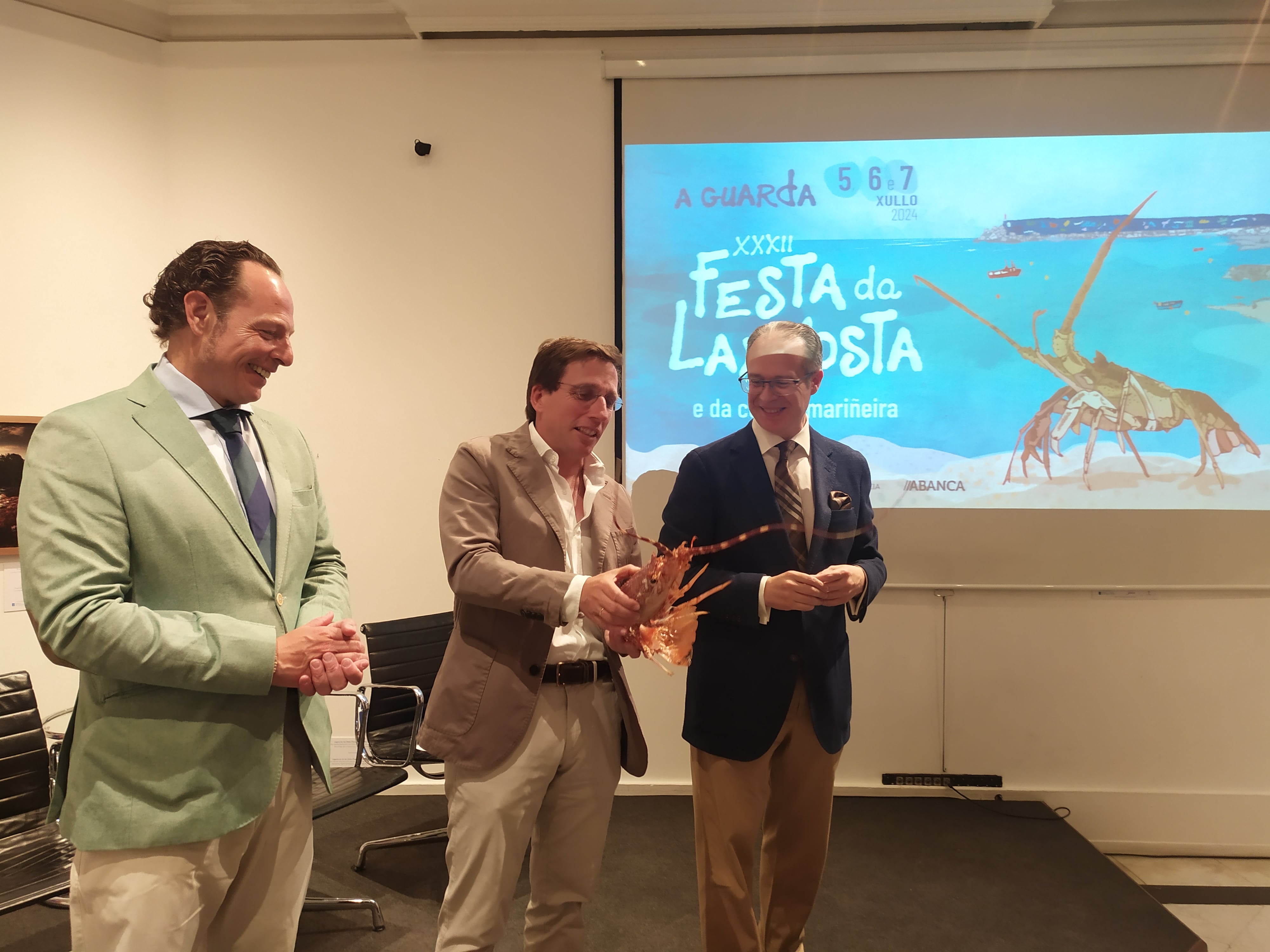 El alcalde de Madrid, José Luis Martínez Almeida (centro), junto al regidor de A Guarda, Roberto Carrero (derecha), durante la presentación de la Festa da Langosta en la Casa de Galicia