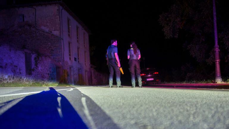 GRAF2228. TURIENO (CANTABRIA), 18.07.2018. Dos agentes de la Guardia Civil cortan la carretera que da acceso al lugar en el que un hombre lleva atrincherado desde las 21.00 horas de hoy en una casa de Turieno, en el municipio cántabro de Camaleño, desde l