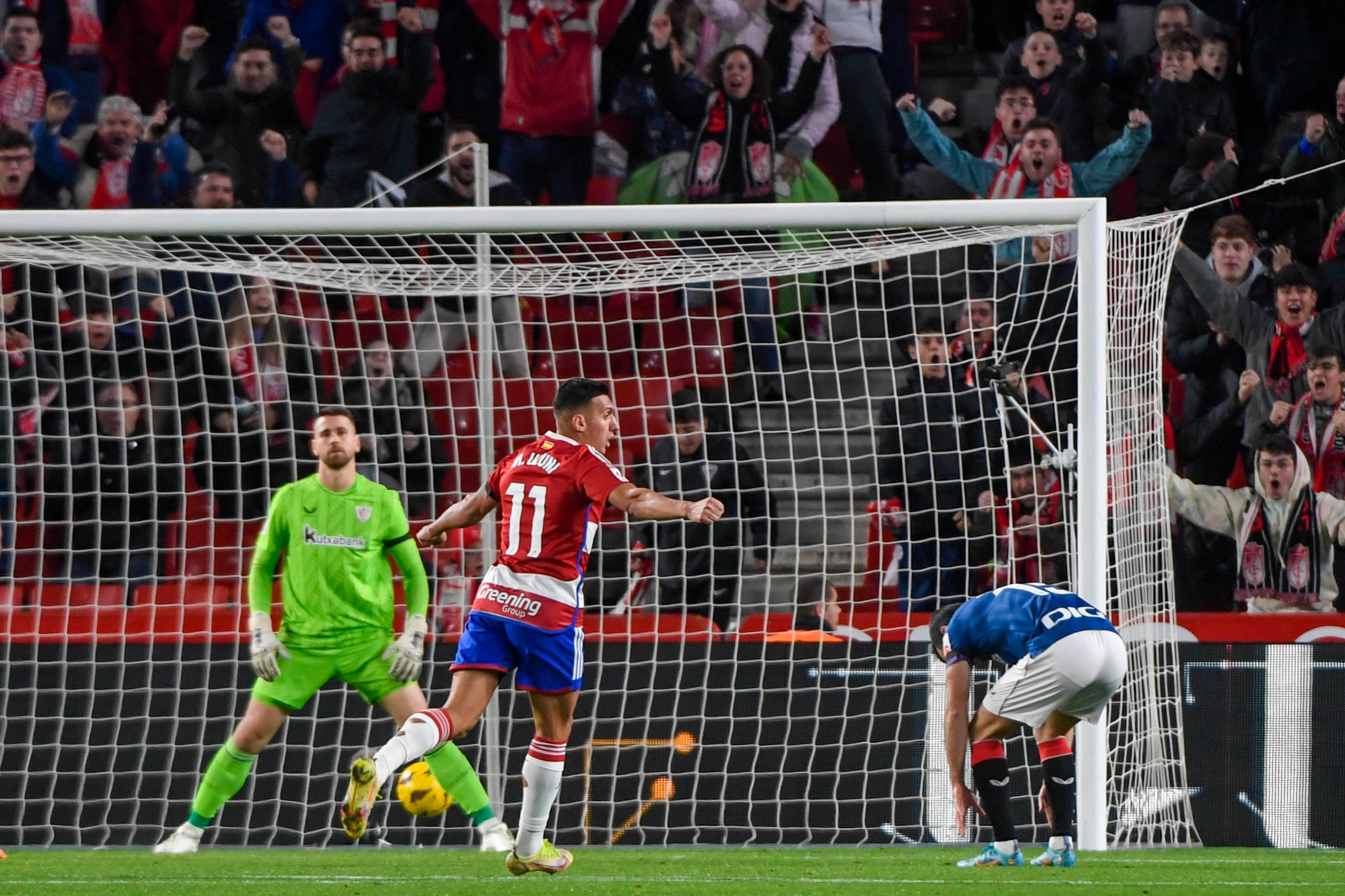 GRANADA, 11/12/23.- El delantero albanés del Granada Myrto Uzuni (c) celebra un gol en propia puerta del centrocampista del Athletic Iñigo Ruiz de Galarreta, durante el encuentro correspondiente a la jornada 16 de Primera División que disputan Granada y Athletic Club en el estadio Nuevo Los Cármenes en Granada, reanudado este lunes tras ser suspendido ayer por el fallecimiento de un seguidor granadino. EFE / Miguel Ángel Molina.
