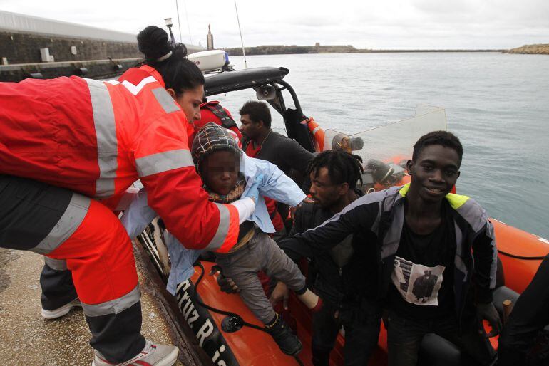 Personal de Cruz Roja ayuda a bajar a un niño de la lancha de Salvamento Marítimo, tras llegar al puerto de Tarifa (Cádiz) con varios de los 31 inmigrantes.