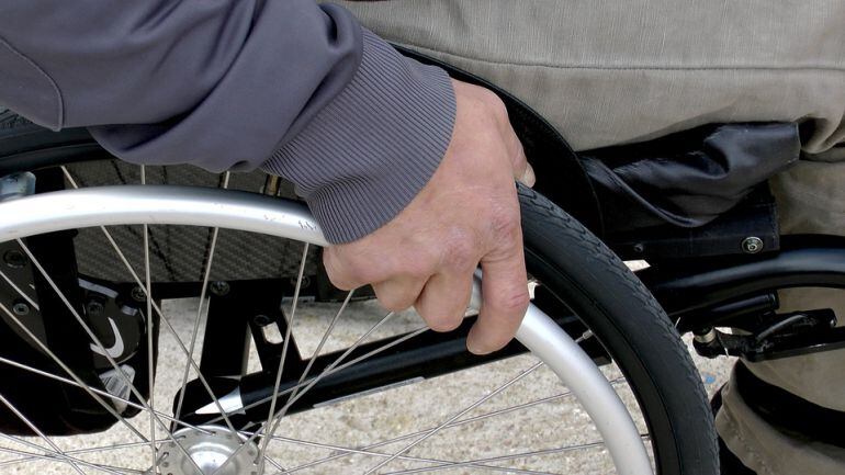 Un hombre monta en una silla de ruedas.