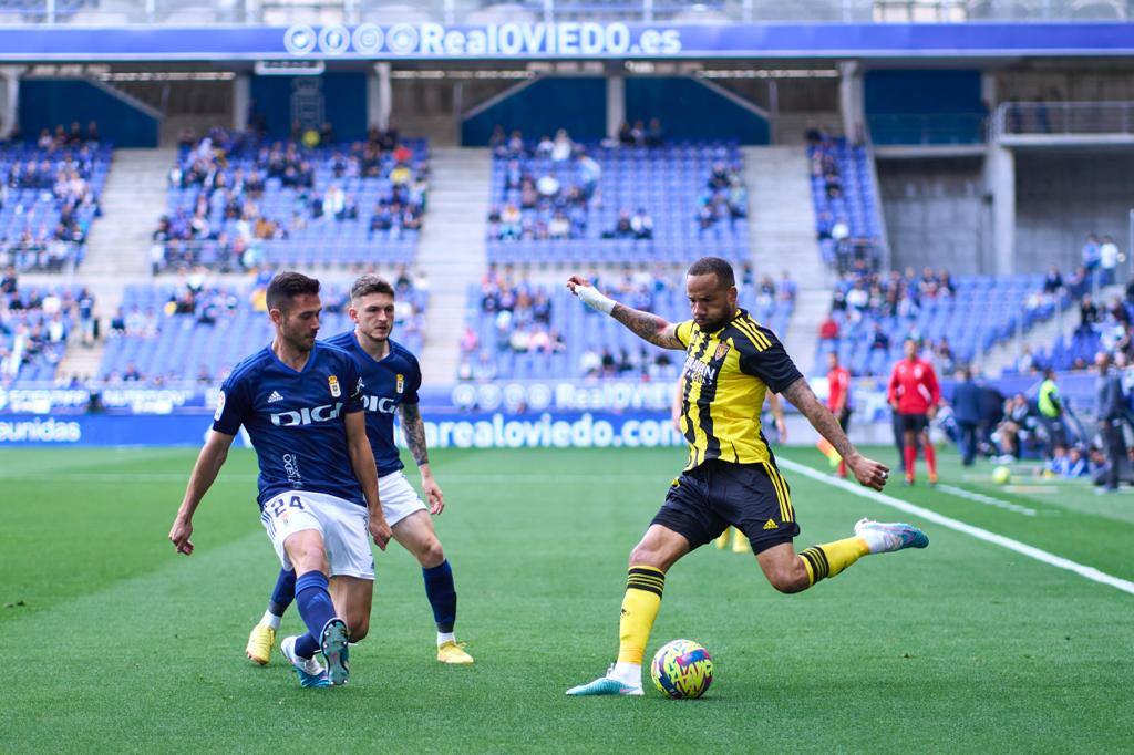 Bebé centra ante la oposición de dos jugadores del Oviedo