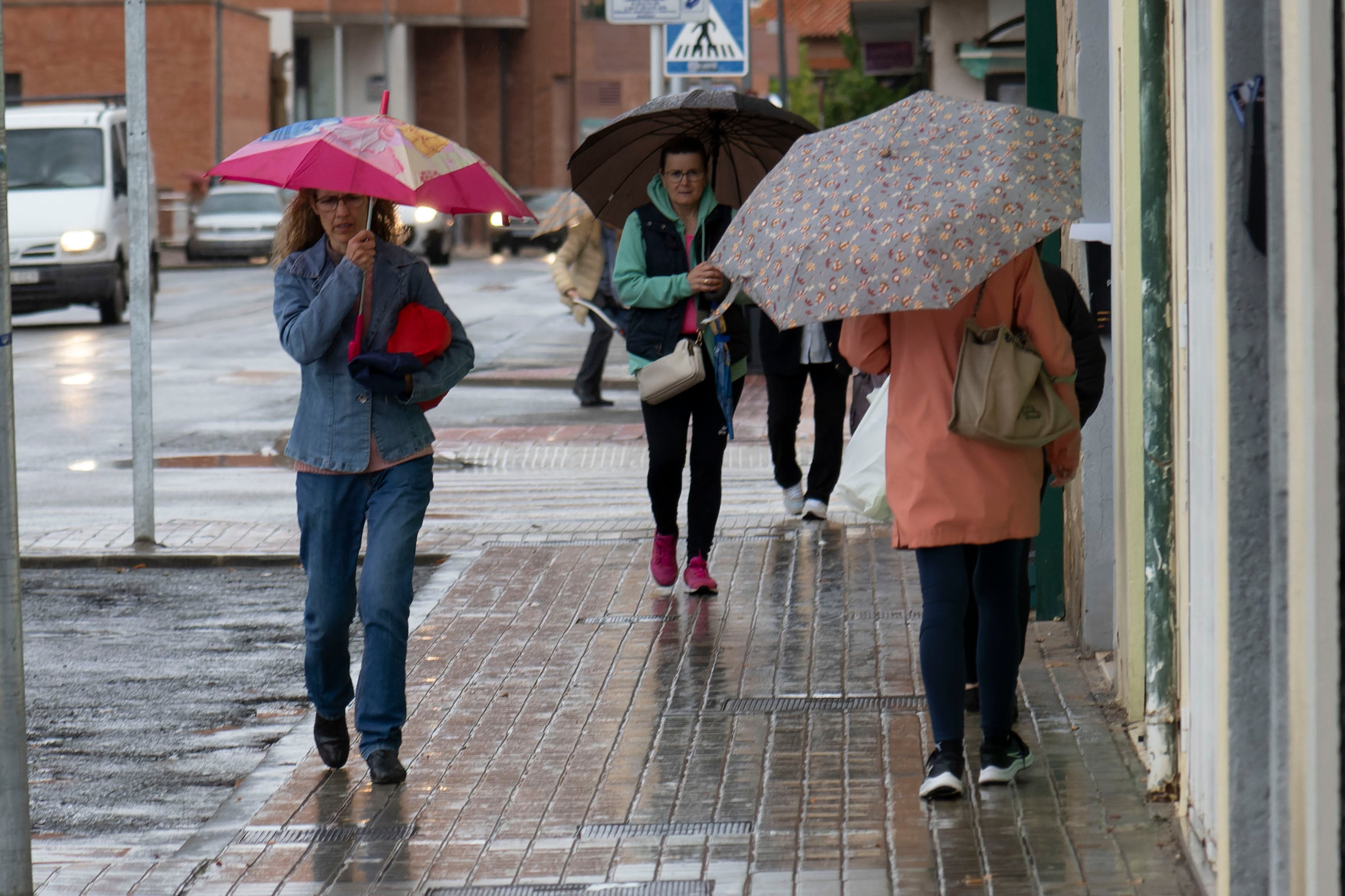 Varios viandantes se protegen de la lluvia