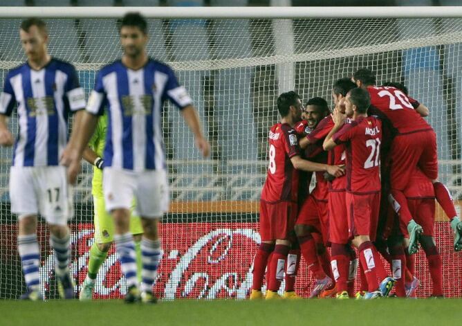 Los jugadores del Getafe celebran el triunfo mientras Zurutuza y Markel camina cabizbajos por el césped.