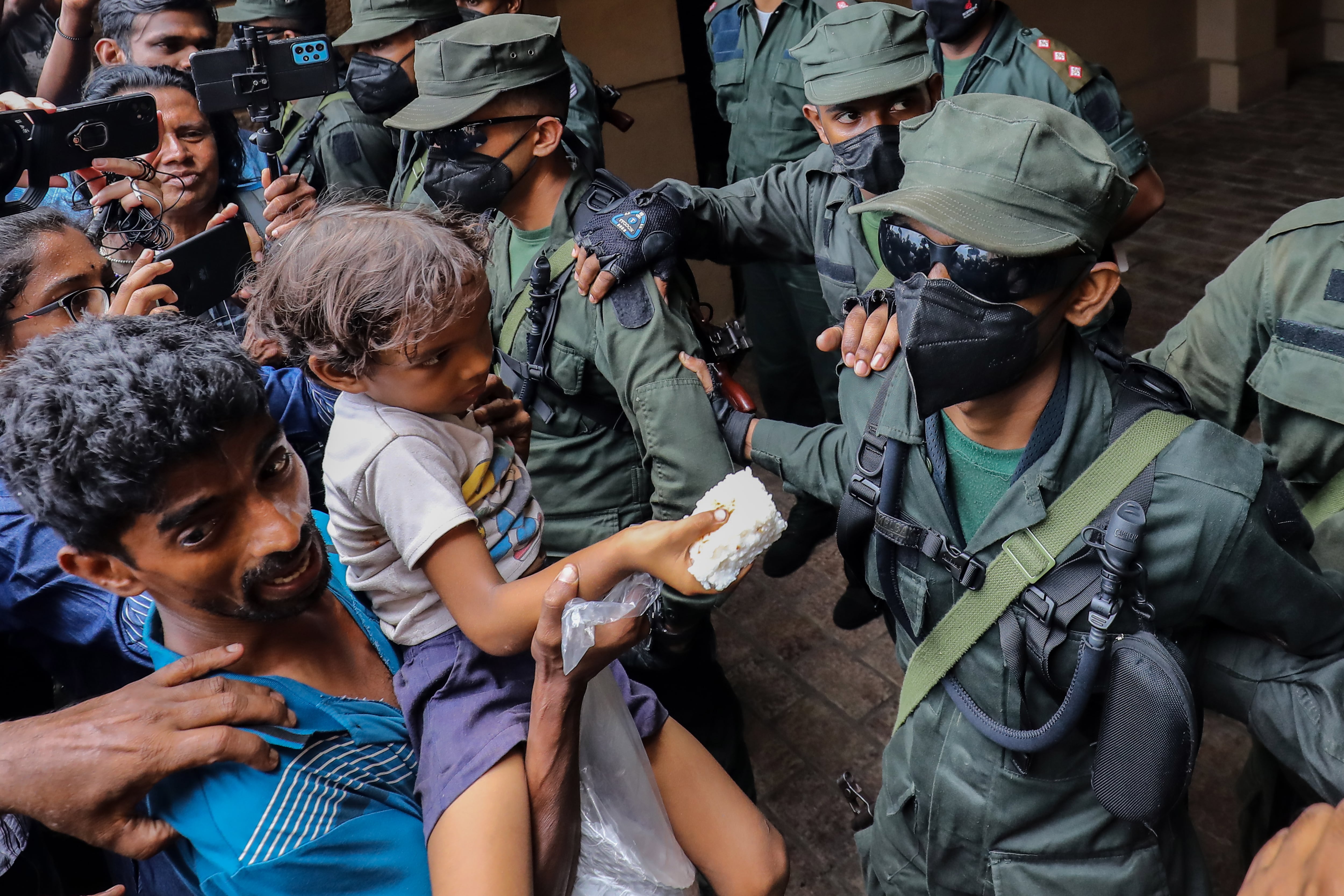 -FOTODELDÍA- COLOMBO, 15/07/2022.- Un grupo de personas ofrece arroz con leche a los soldados del ejército para celebrar la dimisión de Gotabaya Rajapaksa como presidente de Sri Lanka, frente a la Secretaría Presidencial en Colombo, este viernes. El Parlamento de Sri Lanka aceptó el 15 de julio la dimisión de Rajapaksa después de que huyera a Singapur a través de las Maldivas tras meses de protestas antigubernamentales alimentadas por la actual crisis económica. El primer ministro Ranil Wickremesinghe juró como presidente interino el 15 de julio. EFE/ Chamila Karunarathne
