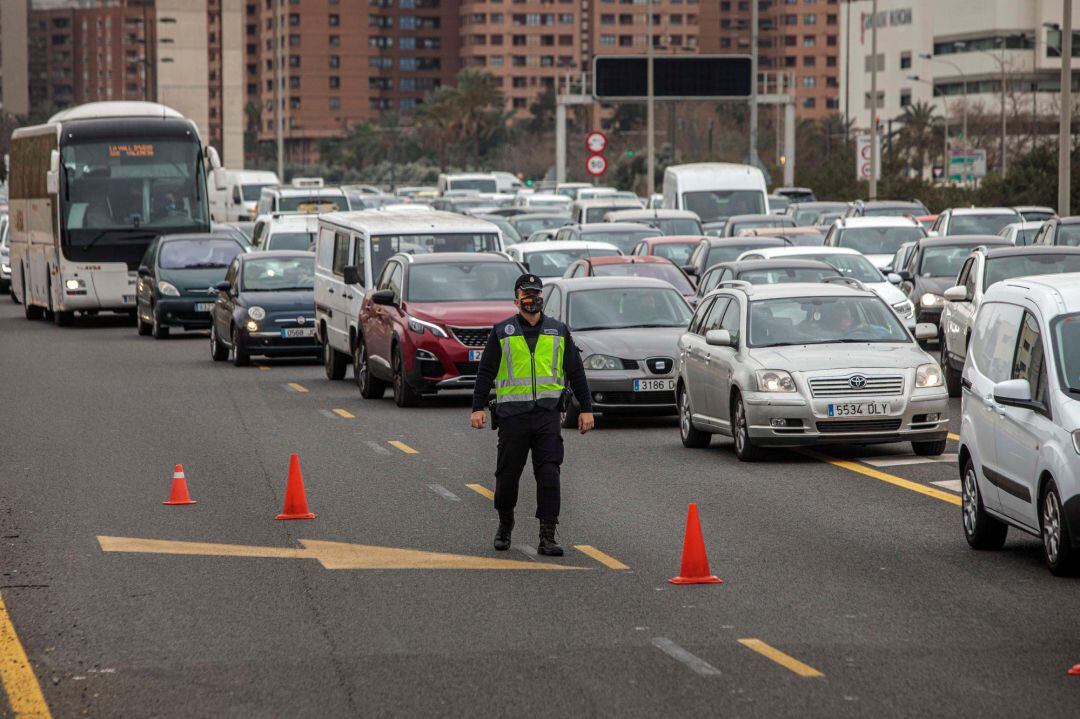 Agentes de la Policia Nacional realizan un control en la salida hacia Barcelona cuando a las 15 horas de este viernes comienza a aplicarse, por segundo fin de semana consecutivo, el cierre perimetral de las dieciséis ciudades de la Comunitat Valenciana de