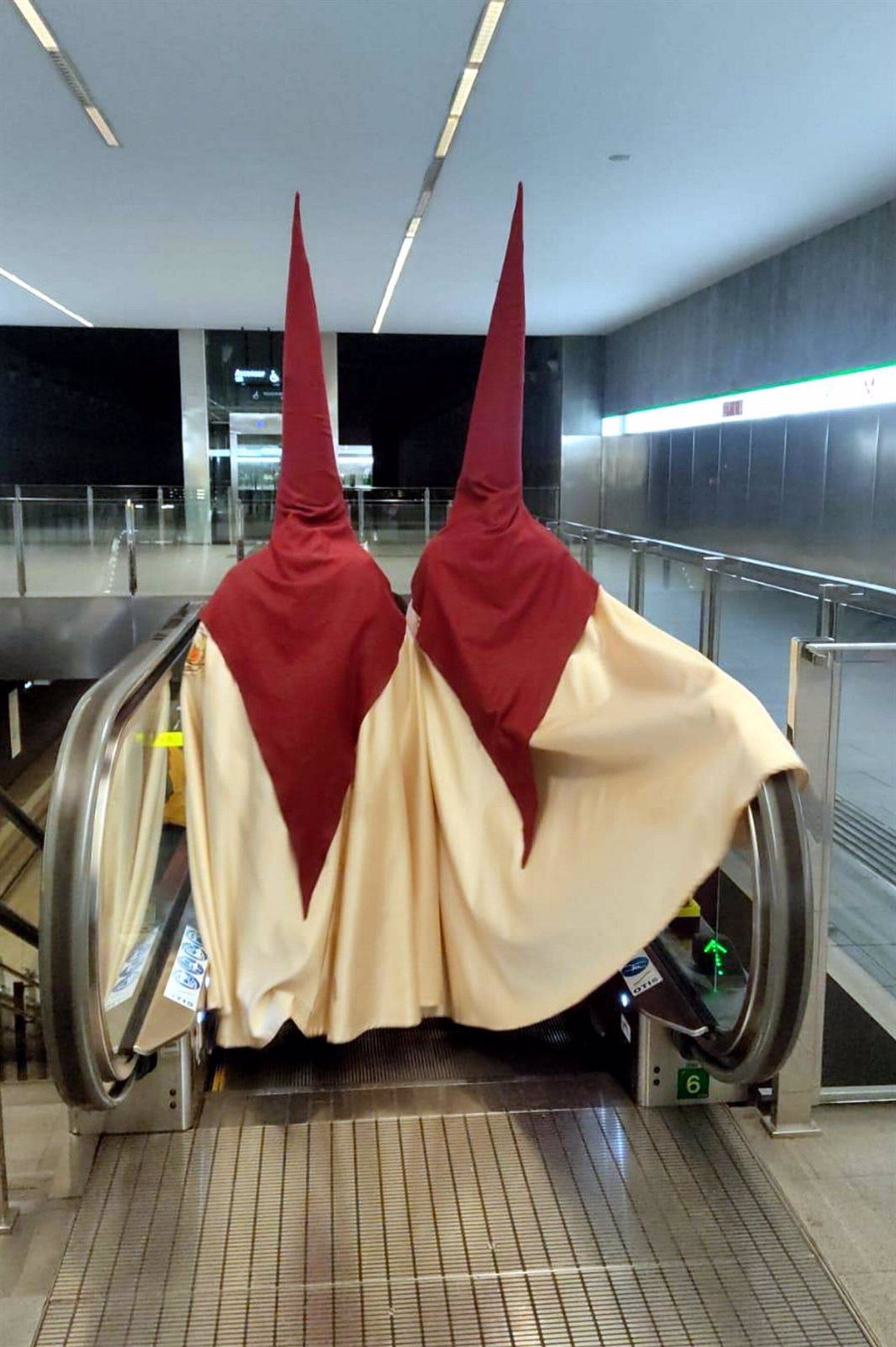 Penitentes descendiendo en una estación de metro en Granada