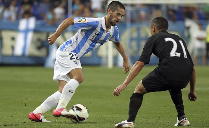 El centrocampista del Málaga CF, Francisco Alarcón &quot;Isco&quot;, intenta marcharse del centrocampista inglés del Everton FC, Leon Osman, durante el partido correspondiente al Trofeo Costa del Sol disputado en el estadio de La Rosaleda en Málaga.