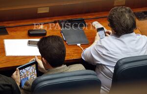 Los diputados del PP Bartolomé González y María Isabel Redondo juegan una partida de Apalabrados durante el pleno en que se ha aprobado, entre otras medidas, la privatización de la gestión de los hospitales públicos madrileños.