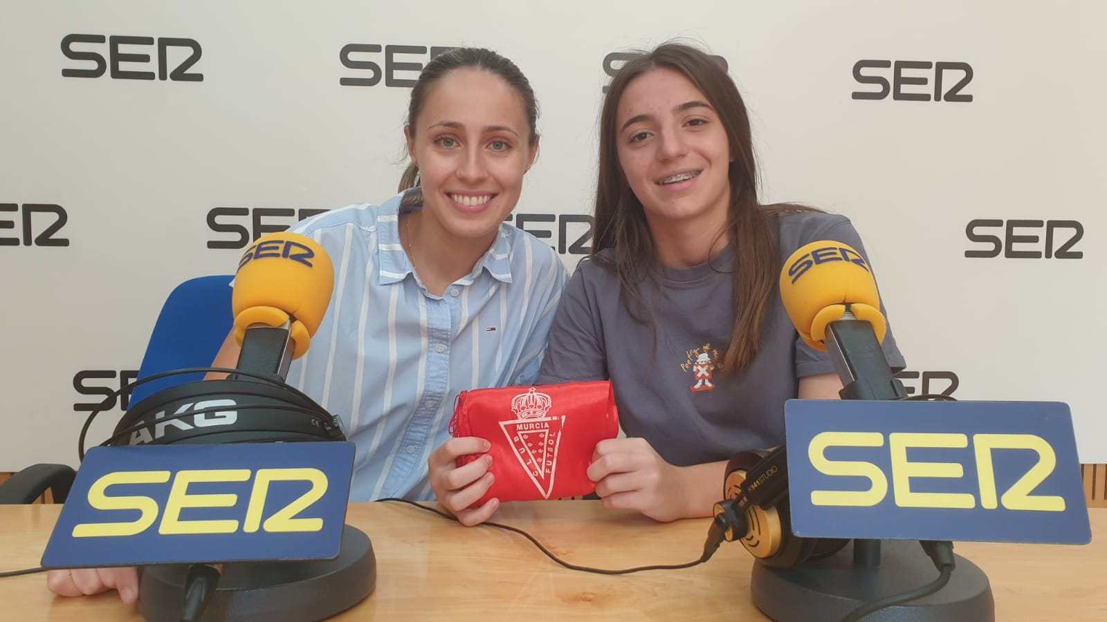 Laura Mazón e Irene Zapata posan con una bufanda del Real Murcia en los estudios de Radio Murcia