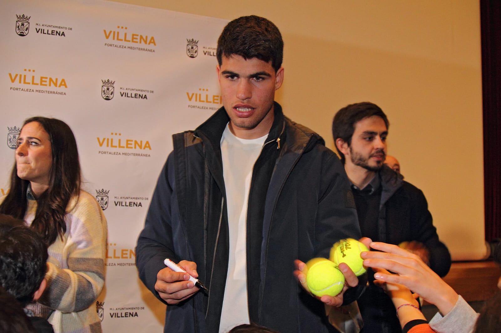 Alcaraz firmando pelotas de tenis a los niños y niñas presentes