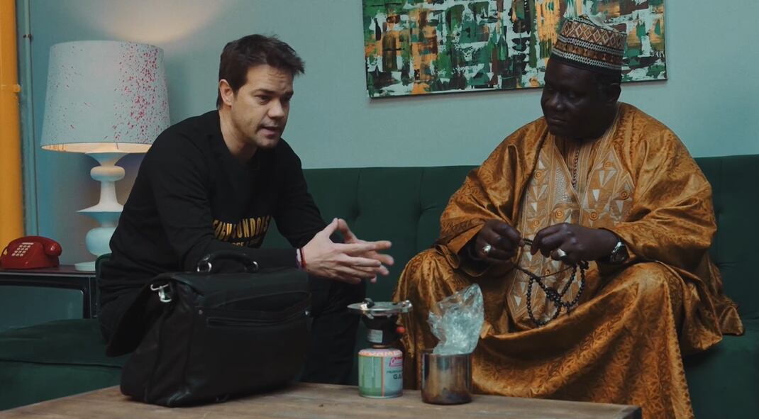 Juan Dávila con un chamán sentados en un sofá