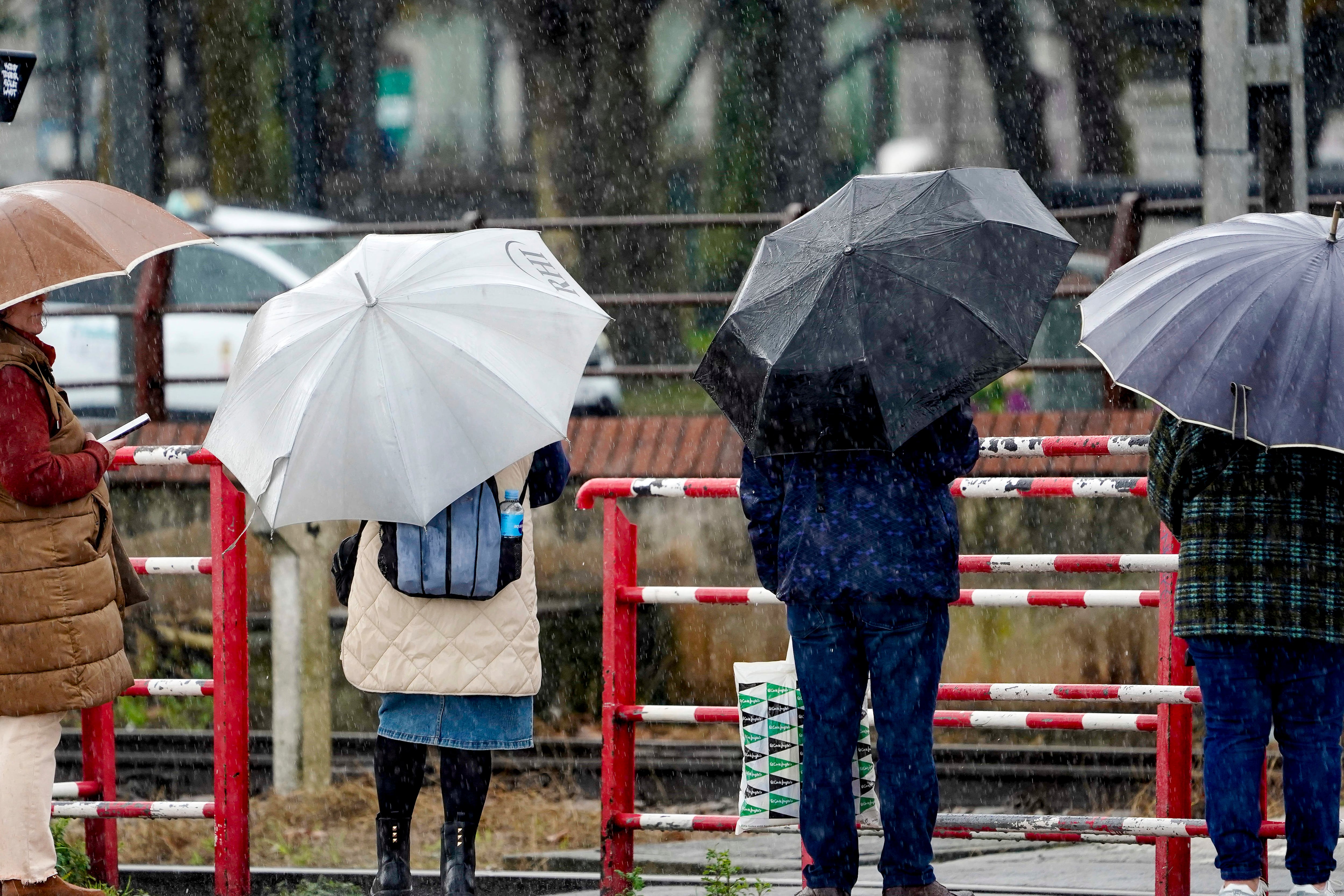 Varias personas bajo una intensa lluvia, en una imagen de archivo.