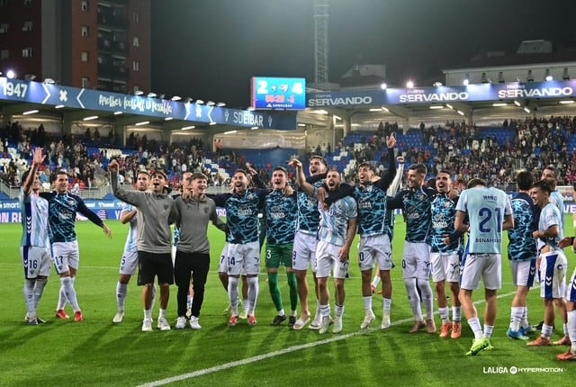 El Málaga celebrando con los aficionados el triunfo ante el Eibar en Ipurua