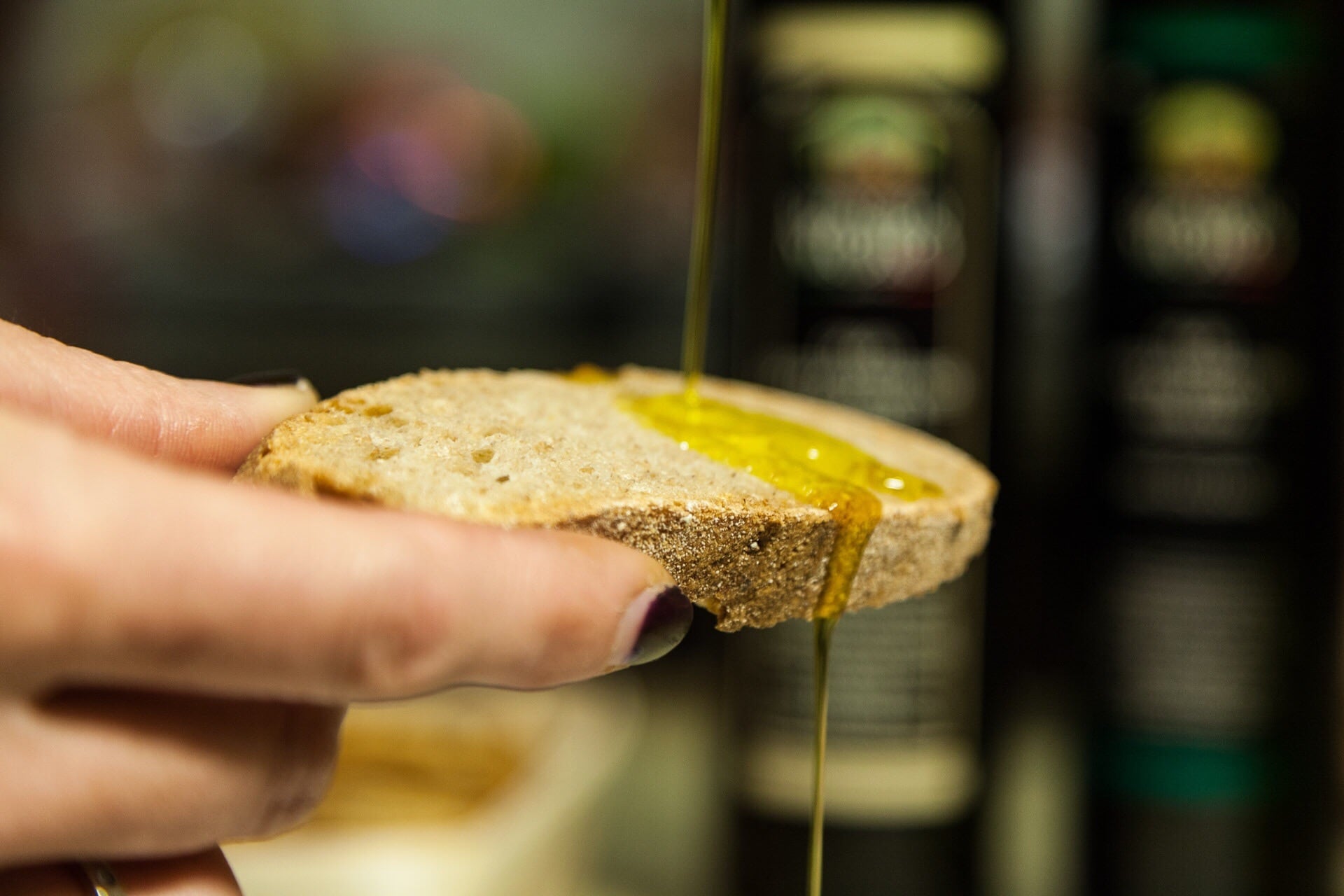 Tostada de pan con aceite de oliva cayendo sobre ella