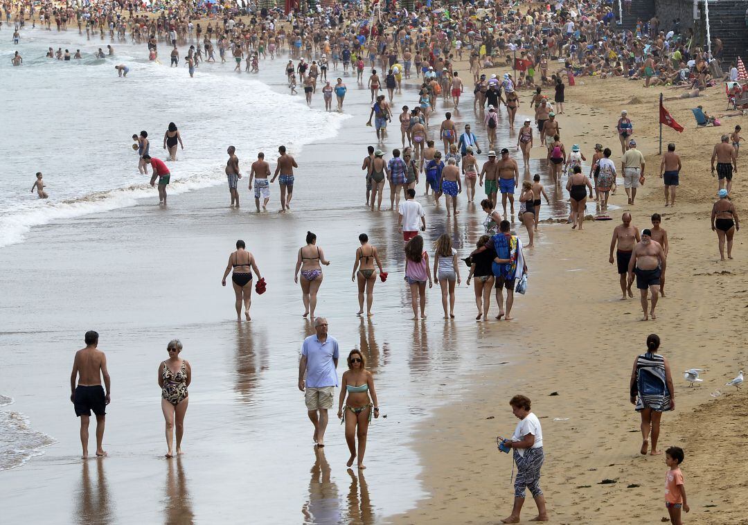 Gente paseando por la Playa de San Lorenzo.