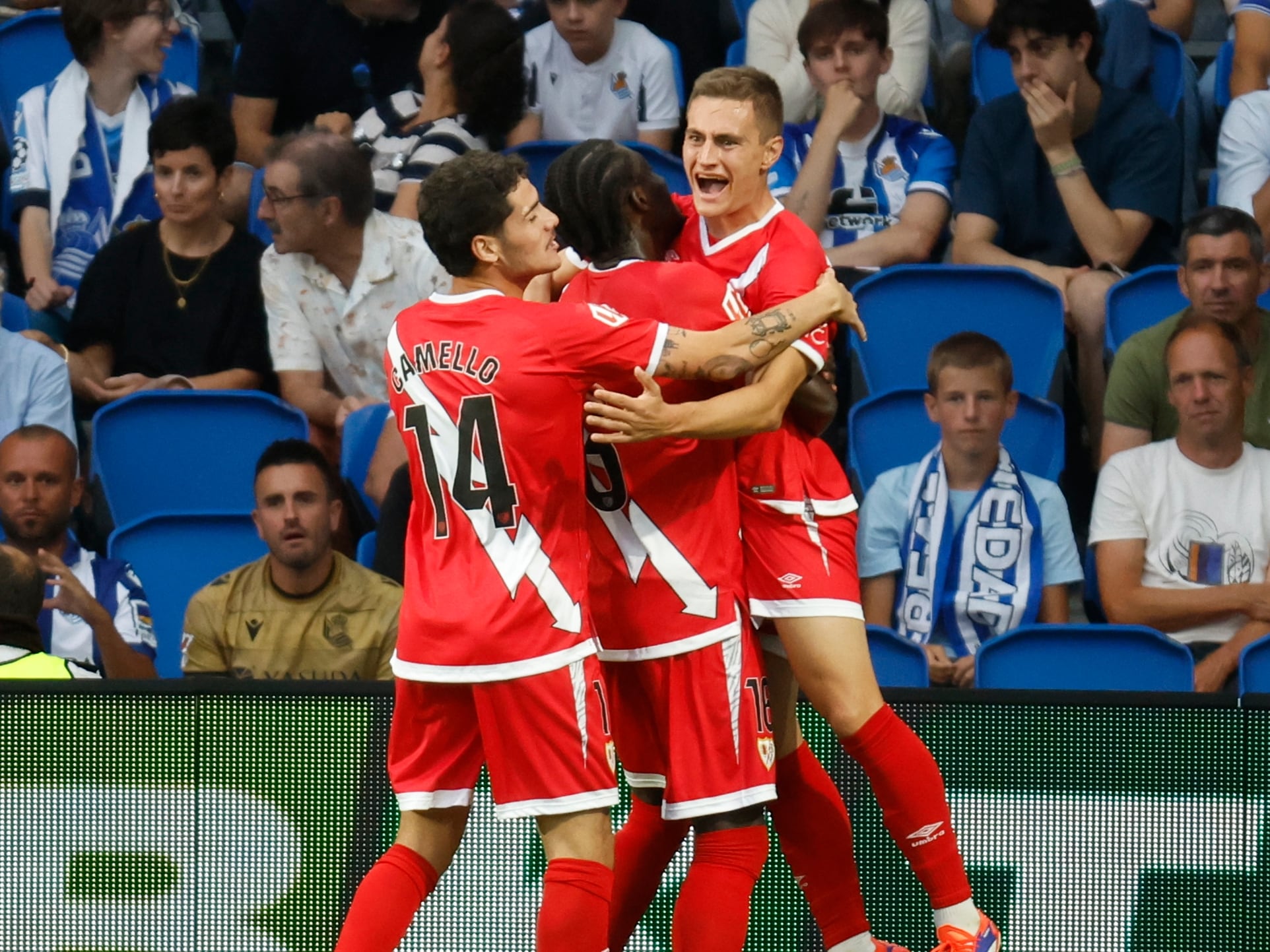 SAN SEBASTIÁN, 18/08/2024.- El centrocampista del Rayo Vallecano Jorge De Frutos (d) celebra con sus compañeros su gol, primero del equipo madrileño, durante el partido de LaLiga entre la Real Sociedad y el Rayo Vallecano, este domingo en el Reale Arena de San Sebastián. EFE/ Javier Etxezarreta
