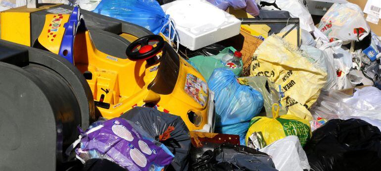 GRA140. PARLA (MADRID), 07/01/2015.- Basura acumulada junto a unos contenedores hoy en una calle de Parla (Madrid), cuando se cumple una semana de huelga en el servicio de limpieza y recogida de basuras de esta localidad madrileña convocada por varios impagos a los empleados por la empresa Garbialdi-Sadifer, que los achaca a la deuda del Ayuntamiento con la adjudicataria. EFE/Chema Moya