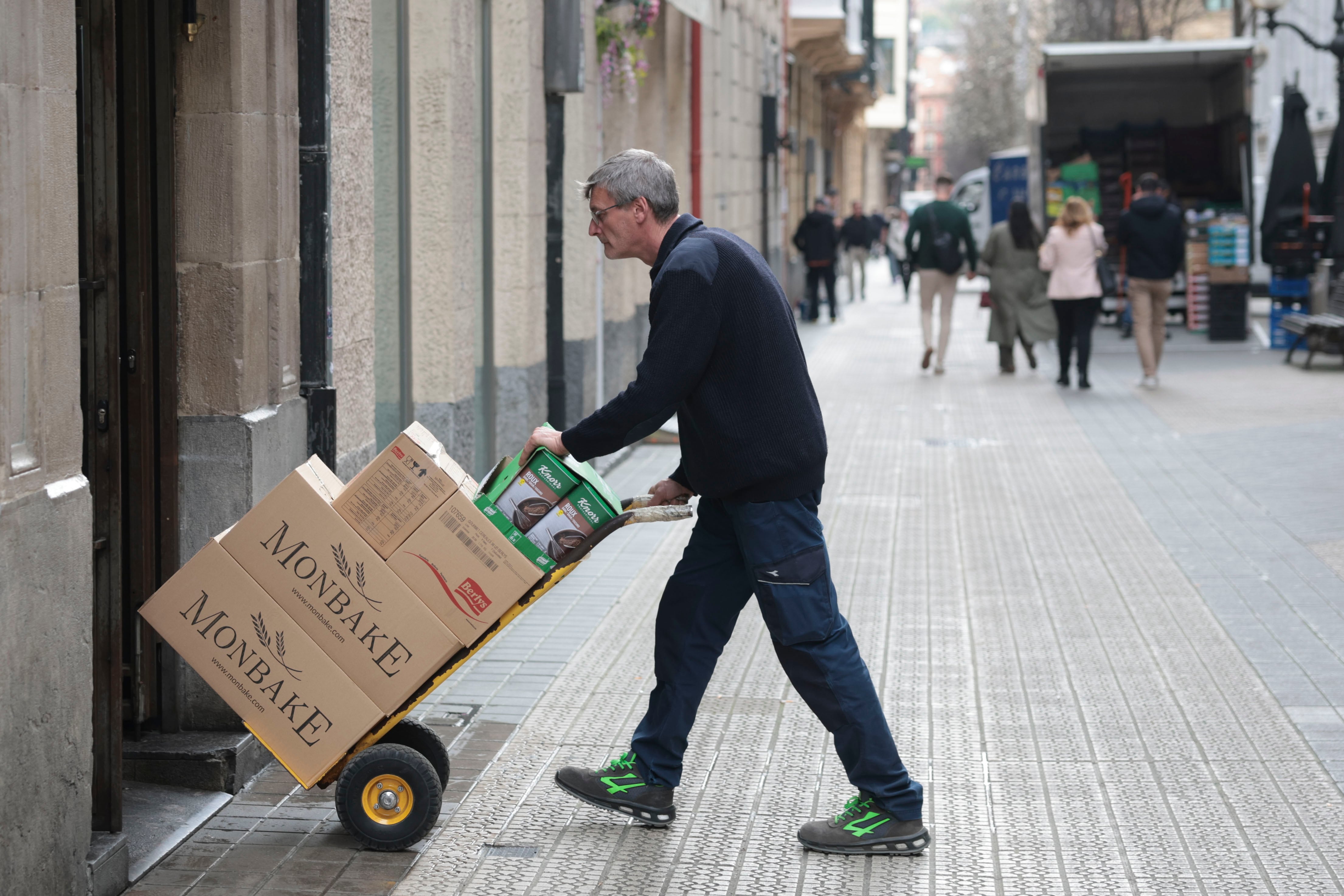 Un transportista mete unas cajas en un restaurante. EFE/Luis Tejido