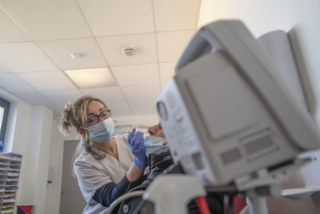 Personal sanitario sometiendo a un joven a una prueba PCR. 