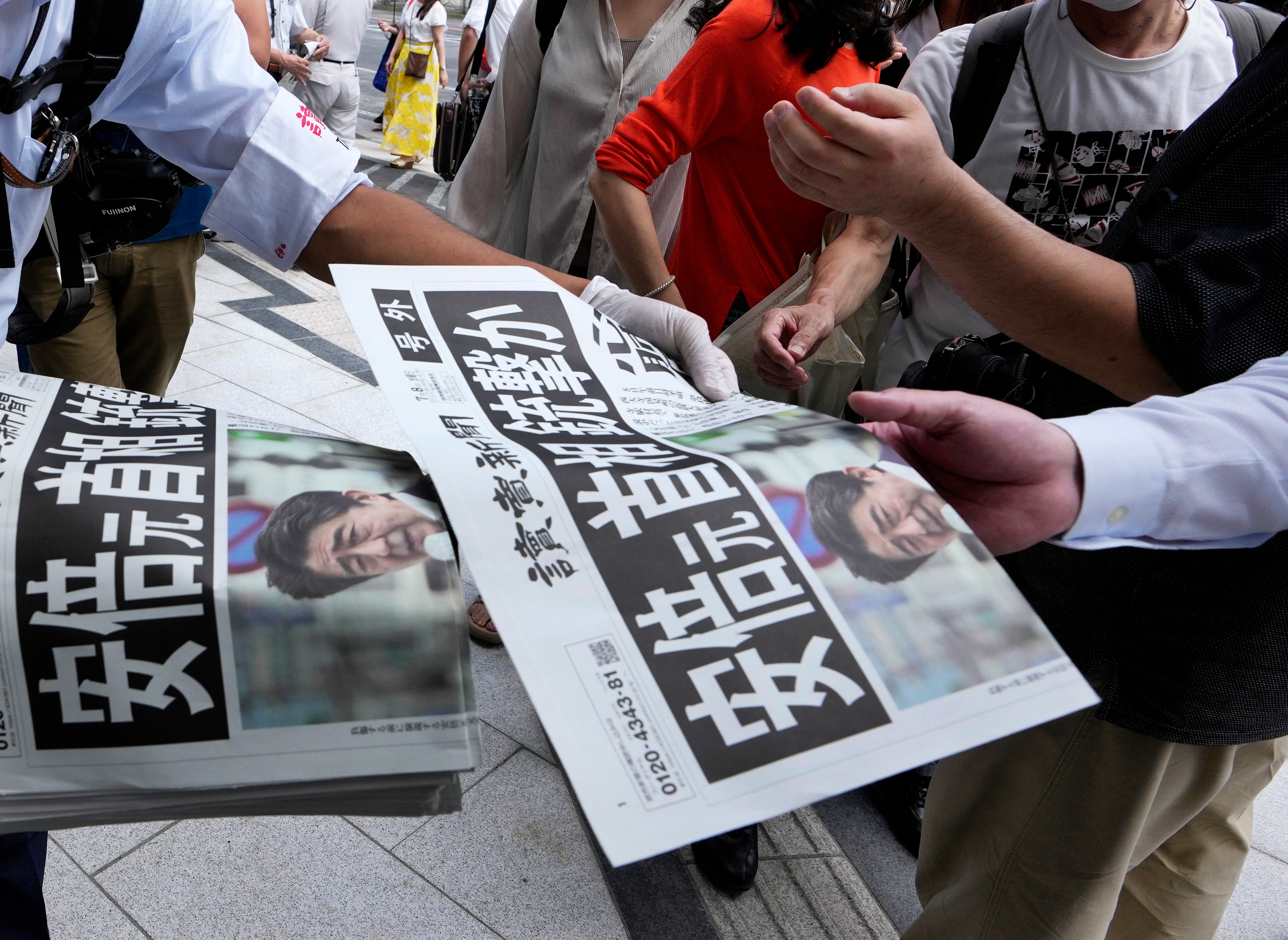 Ciudadanos leen la prensa que ya recoge el atentado contra Shinzo Abe.