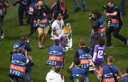 Marcelo, rodeado de fotográfos, le ofrece el trofeo al público desplazado