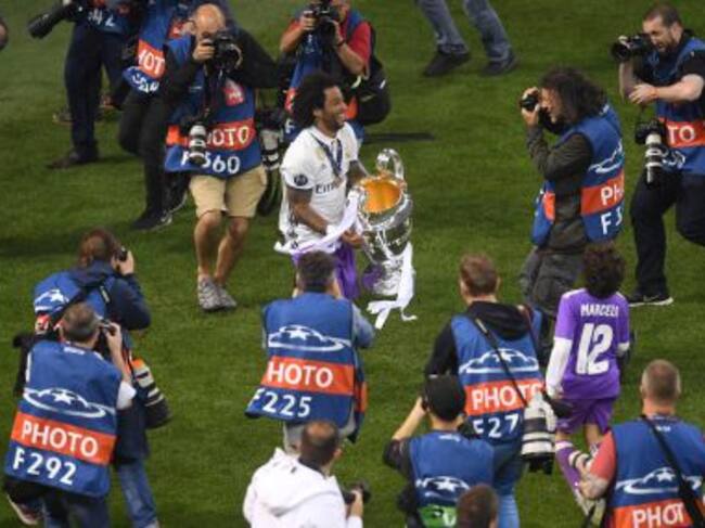 Marcelo, rodeado de fotográfos, le ofrece el trofeo al público desplazado