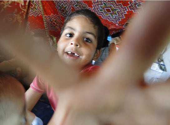 Un niño saharaui intenta alcanzar la cámara de fotos del corresponsal de Cadena SER en Marruecos, Eduardo Marín, en el campamento de El Aaiún.