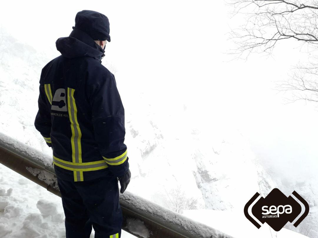 Un bombero revisa el terreno marcado por la nieve y la niebla. 