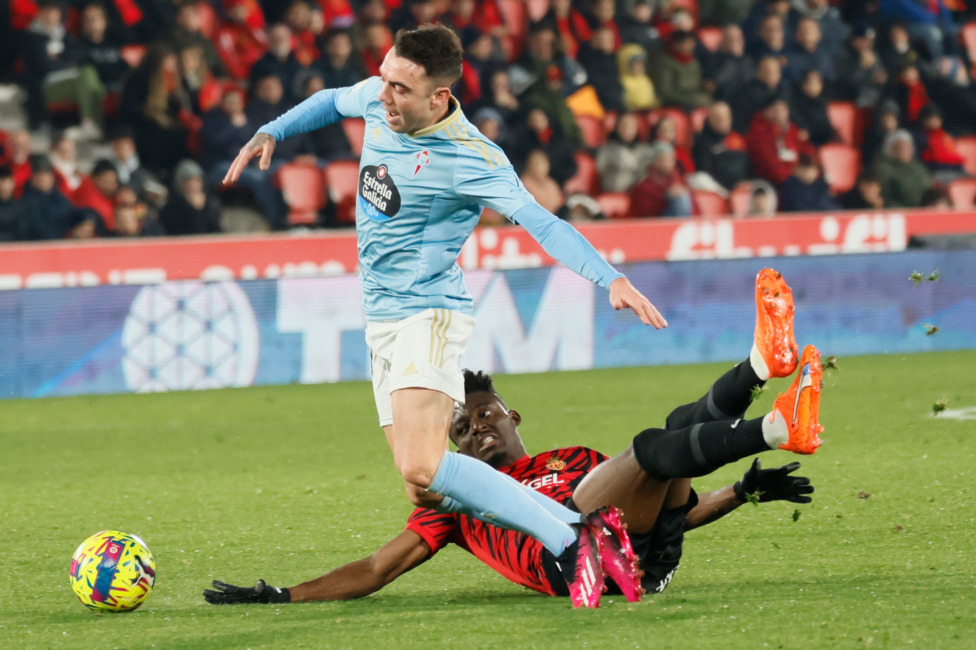 PALMA DE MALLORCA, 20/01/2023.- El delantero del Celta Iago Aspas (i) cae ante Iddrisu Baba, del Mallorca, durante el partido de Liga en Primera División que RCD Mallorca y Celta de Vigo disputan este viernes en el estadio de Son Moix, en Palma de Mallorca. EFE/Cati Cladera