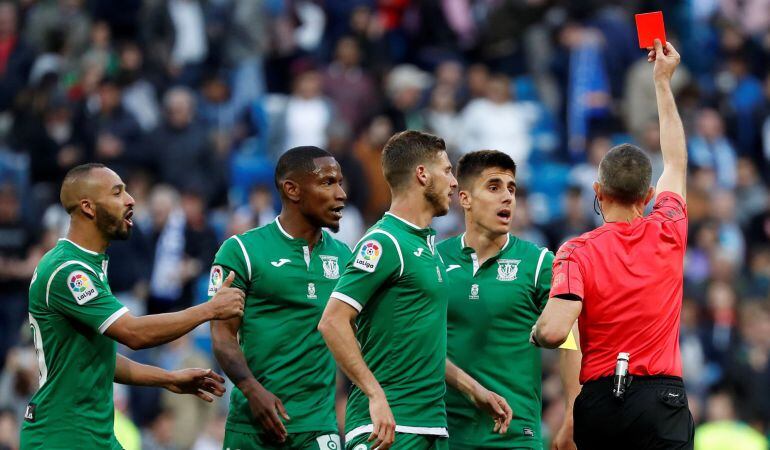 El árbitro Iglesias Villanueva (d) expulsó así al jugador del Leganés Gabriel Pires (fuera de la imagen) al final del partido frente al Real Madrid correspondiente a la jornada 34 de la Liga Santander de fútbol disputado en el estadio Santiago Bernabéu. 