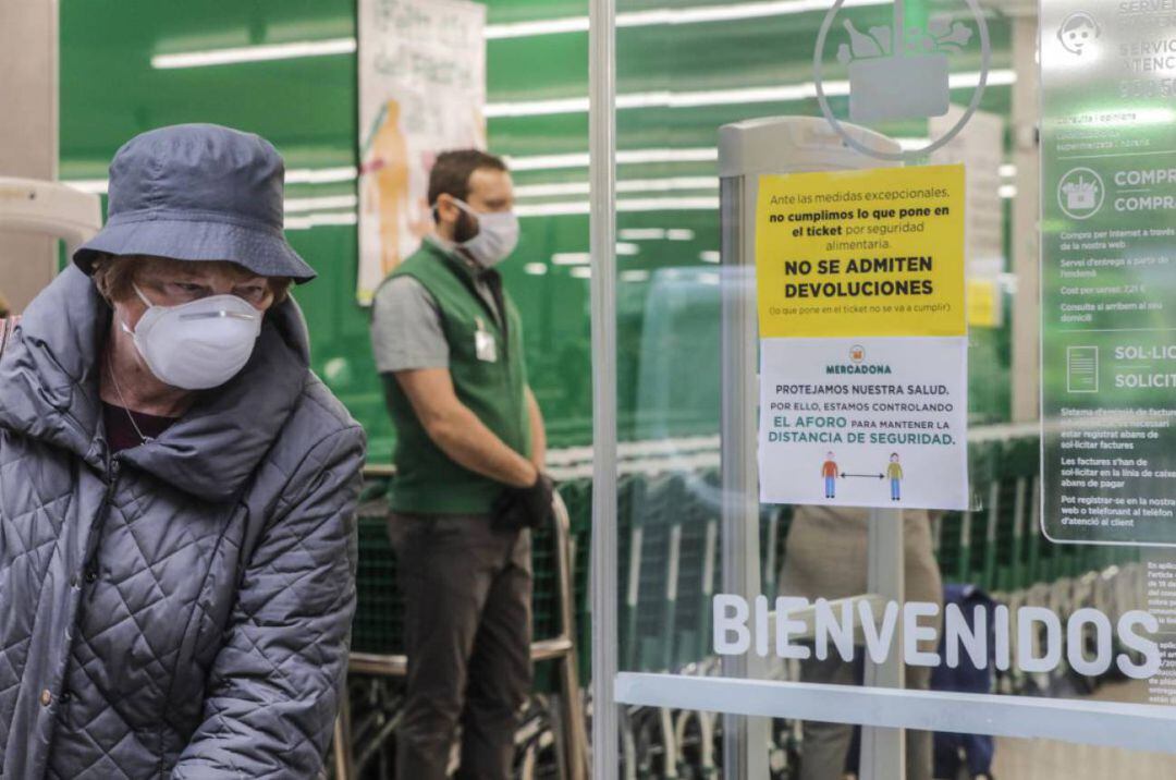 Una mujer con mascarilla en la puerta de Mercadona